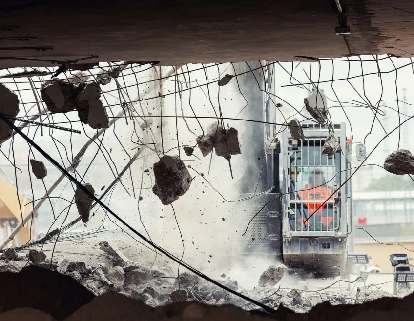 Professional commercial demolition machinery breaking down a reinforced concrete structure for a site redevelopment project in Dallas.