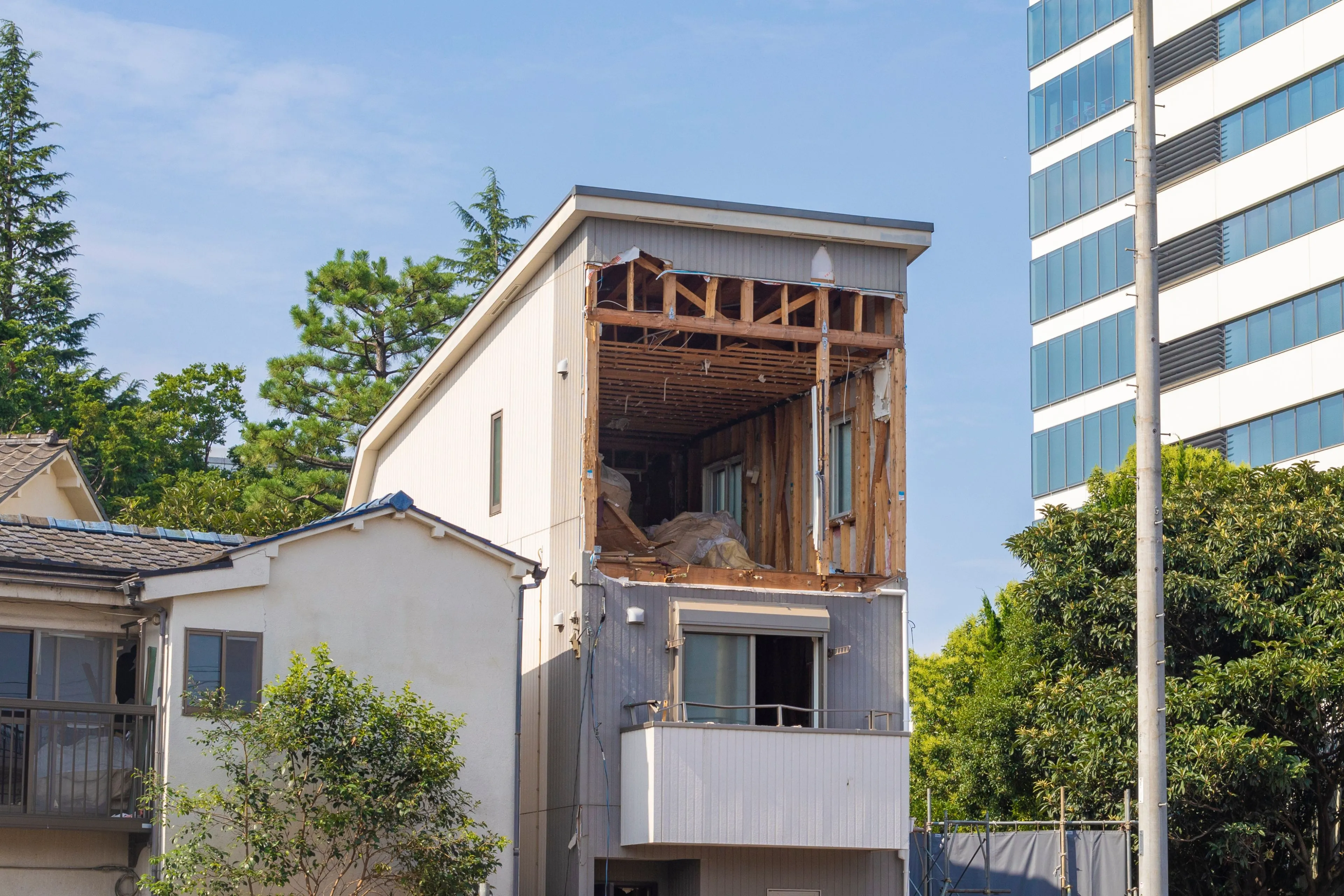 Partial structural demolition of a multi-story building in Dallas, showcasing selective dismantling while preserving the surrounding property.